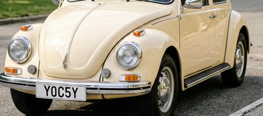 A cream classic Volkswagen Beetle parked on a residential street