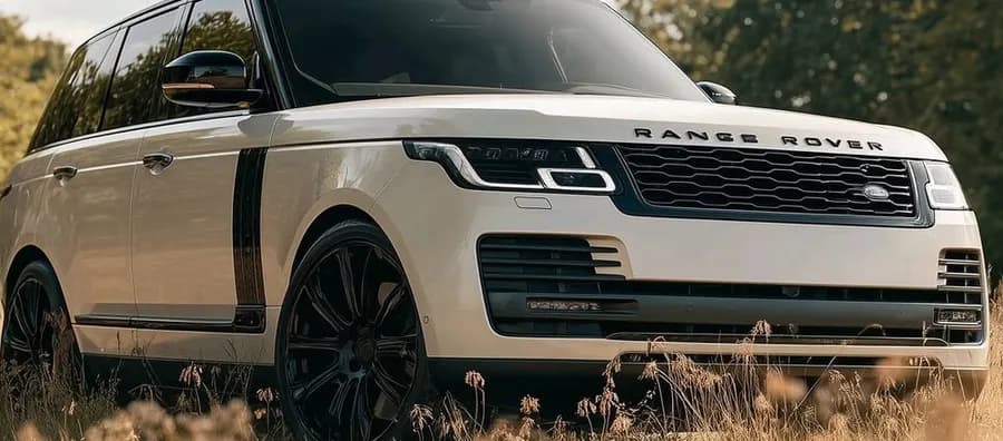 A white large sport utility vehicle parked on dry grass